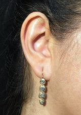 Dangle Diamond Earrings in gold on ear