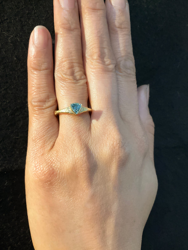 Forged Trillion Cut Blue Zircon Ring in 18k gold on hand