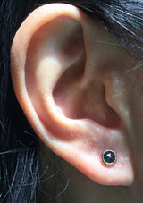 Black diamond stud earrings on ear