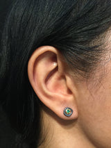 Emerald stud earring on ear