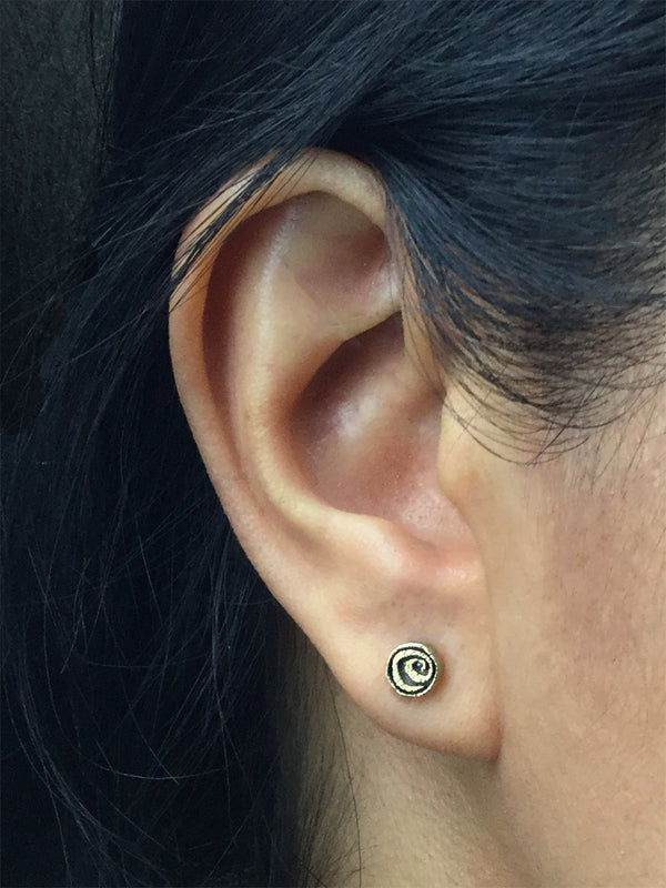 Gold Spiral Stud earrings on ear